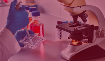 Biotechnologin arbeitet mit Pipette und Mikroskop