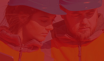 Gesichter von Geodiätinnen mit blauen Helmen, die konzentriert auf etwas gucken