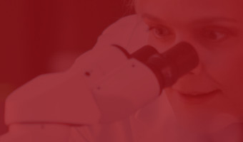 Life Science Engineer blickt durch ein Mikroskop